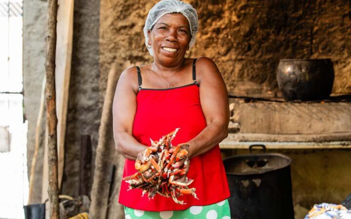 Mulher com caranguejos no litoral sul da Bahia